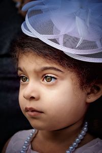 Close-up of girl wearing headwear looking away