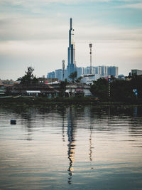 View of factory by river against sky