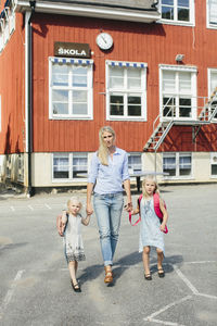 Full length of father with daughter against building