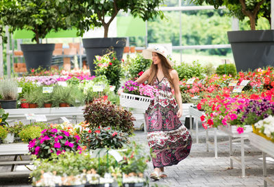 Woman standing by flower pot