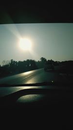 Sun shining through car on road