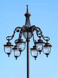 Low angle view of street light against clear blue sky on sunny day