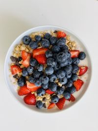 Close-up of berry fruits in bowl on white background