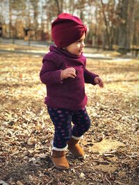 Full length of baby girl standing in park during autumn