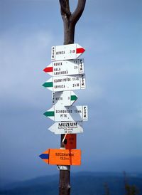 Information sign by pole against sky