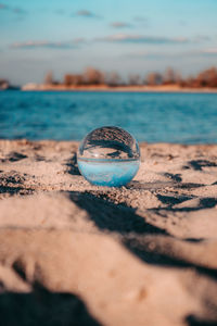 Close-up of crystal ball on beach