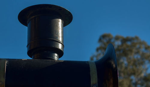 Low angle view of metal against blue sky