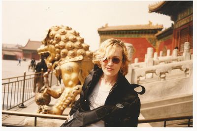 Portrait of woman in sunglasses against sculpture