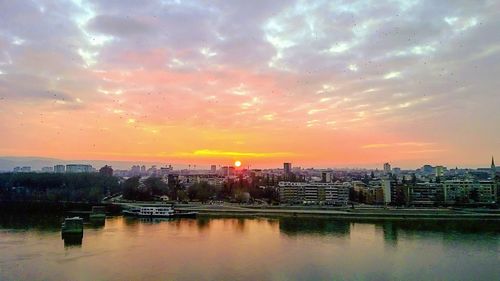 Scenic view of river against cloudy sky during sunset