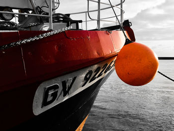 Close-up of moored at harbor against sky