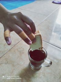 Midsection of person holding ice cream on table