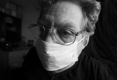Close-up of mature man wearing flu mask at home