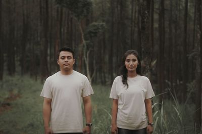 Portrait of young man standing in forest