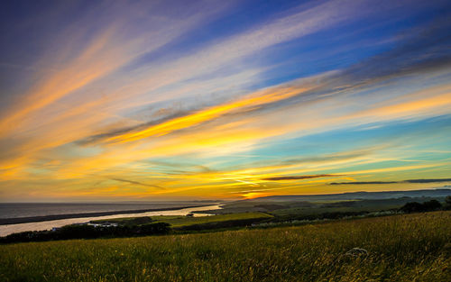 Scenic view of field against sky during sunset