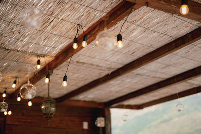 Low angle view of illuminated pendant light hanging from ceiling