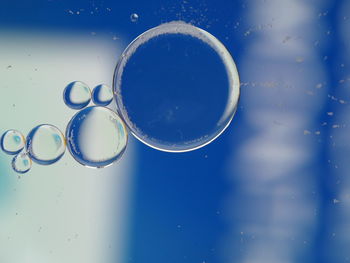 Bubbles forming a line in various sizes against a blue background