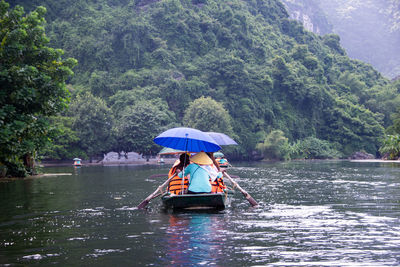 People in boat on river during rainy season