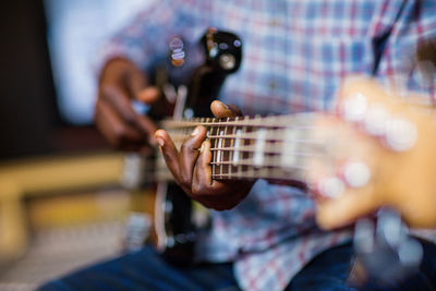 Midsection of man playing guitar