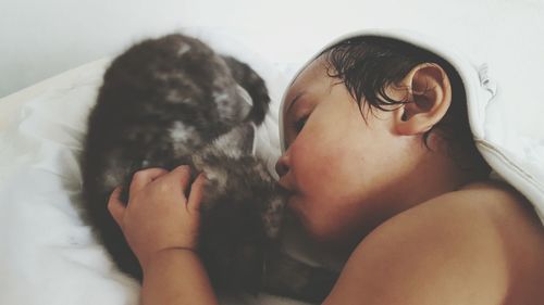 Close-up of cute girl sleeping with cat on bed at home