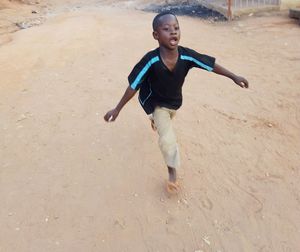 Full length of happy boy running on beach