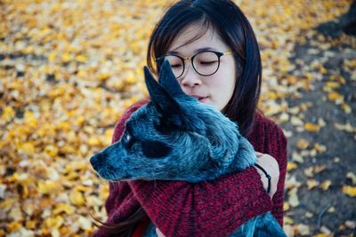 Close-up of woman with autumn leaves