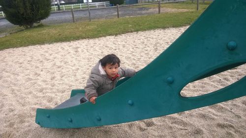High angle portrait of boy playing on slide in playground