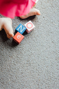 Low section of toddler sitting by toys on carpet at home