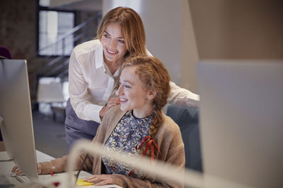 Colleague helping young woman at work