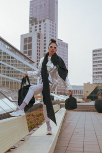 Full length of woman standing against buildings in city