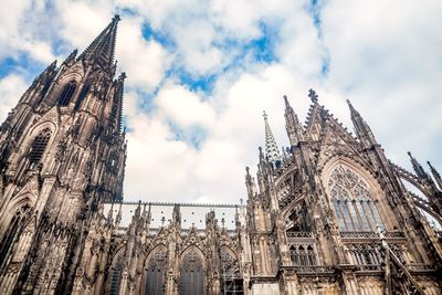 Low angle view of cologne cathedral against cloudy sky