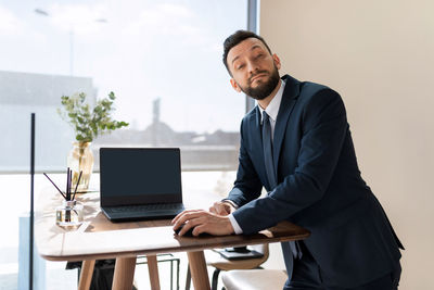Salesman leaning at desk in office