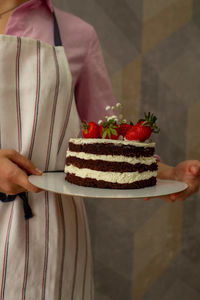 A pastry chef holding a sponge cake on a tray