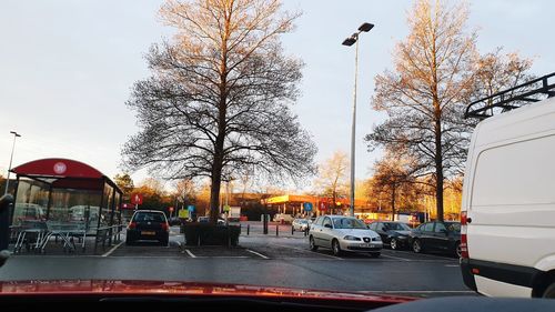 Cars on street in city against sky
