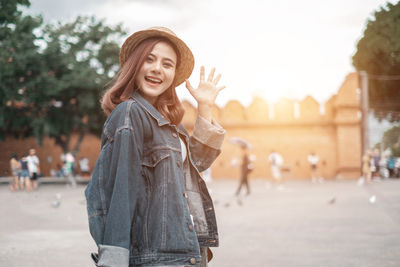 Portrait of smiling young woman standing in city