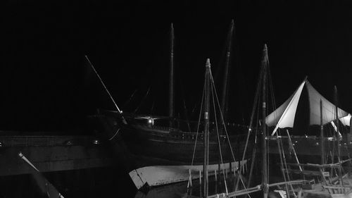 Boats sailing in harbor against sky at night