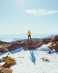 Man standing on shore against sky