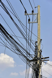 Low angle view of electricity pylon against sky