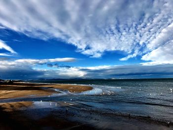 Scenic view of beach against blue sky