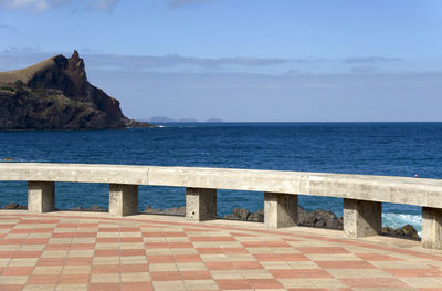 Scenic view of mountain by sea against sky seen from promenade