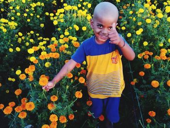 Full length of girl standing on yellow flowering plants