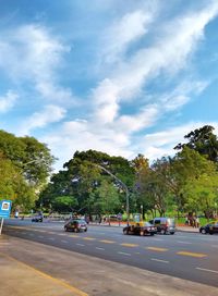 Cars on road in city against sky