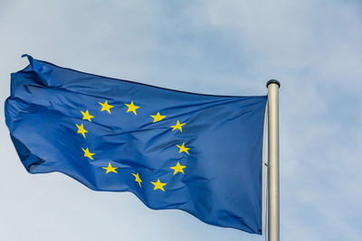 Low angle view of flags against blue sky