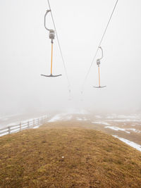 Empty t-bar lift in heavy fog in ore mountains, klinovec. end of season in foggy weather