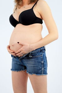 Midsection of woman standing against white background