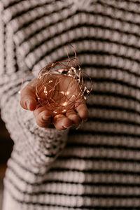 Midsection of woman holding string light