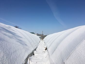 Snow covered land against sky