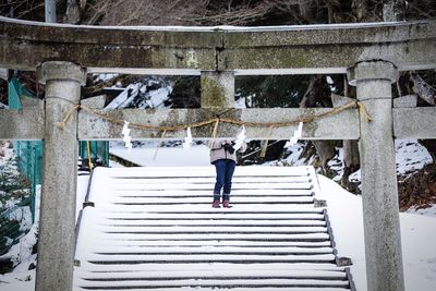 Rear view of man standing on staircase