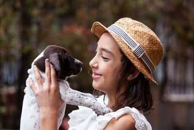 Beautiful young girl having fun with her small french braque puppy