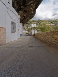 Road amidst buildings against sky