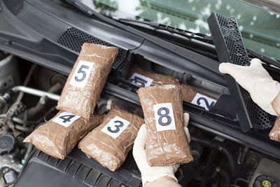 Cropped hand of person holding packet in car